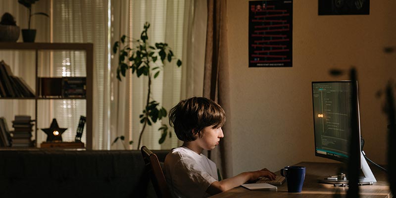 Boy using coding skills at the computer. 