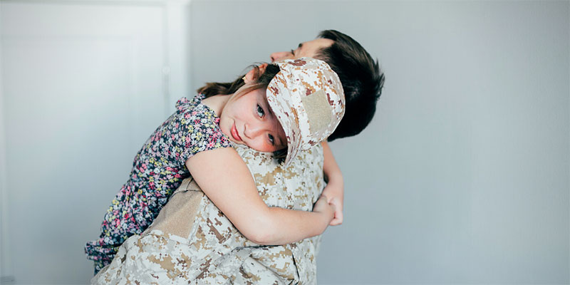 A girl is held by her father